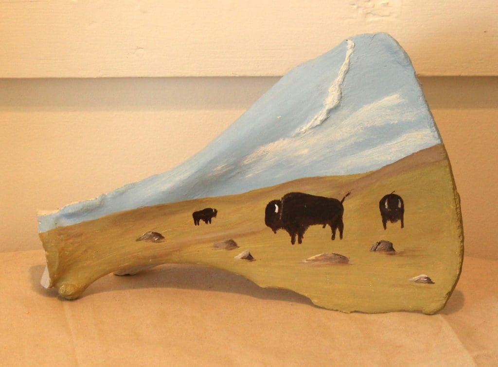 Oil painting by Lise Perrault, on bovine scapula, depicting bison on a prairie dog town.